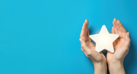 Two hands holding glowing star-shaped light against blue background