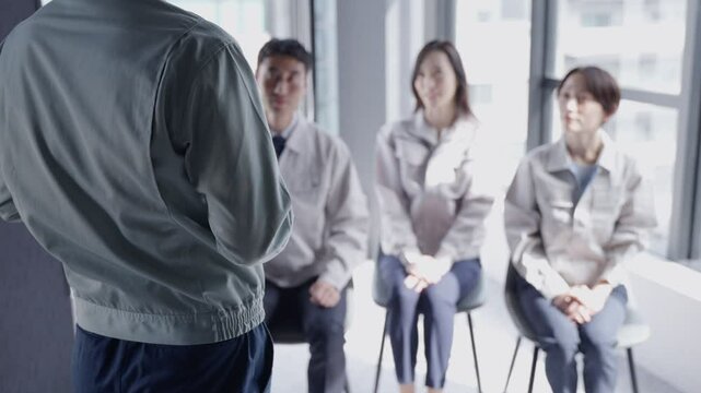 プレゼンする作業着の男性