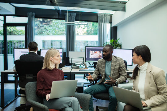 Diverse colleagues talking in modern office sitting space - Powered by Adobe