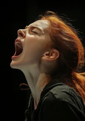 Dramatic shot of a woman yelling with fiery hair against a black background