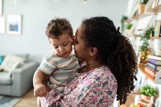 Affectionate mother holding her toddler son in a cozy home setting