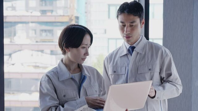 会話する作業着のビジネスマンたち