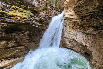 A waterfall is flowing into a pool of water