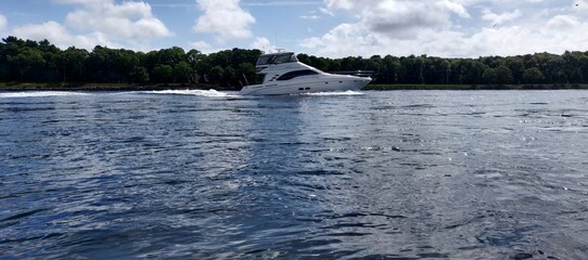 A boat is in the water with a small wave behind it