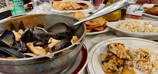 Delicious Seafood Feast with Rice and Crispy Potato Slices on a Table