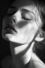 Naklejka premium Captivating portrait of a woman with soft features and delicate lighting in black and white