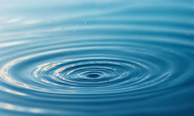 A single water droplet creates concentric ripples on a serene blue surface, capturing the elegance of motion and the tranquility of nature. This image symbolizes simplicity, purity, and the ripple eff
