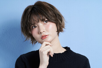 悩む表情をするショートカットの若い女性