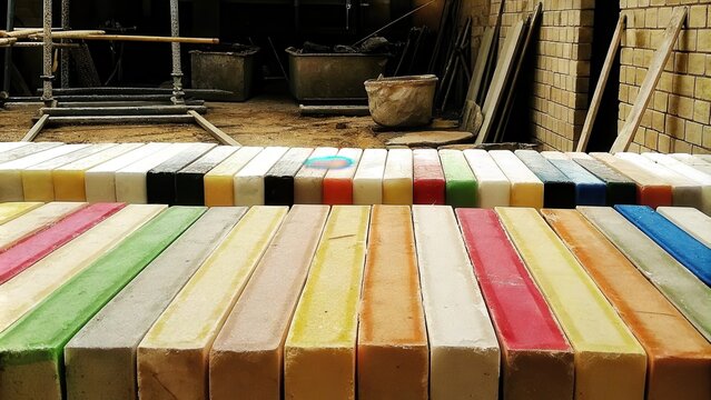 A vibrant environment filled with colorful ecobricks produced from mixed industrial waste being neatly stacked in preparation for a future building project.