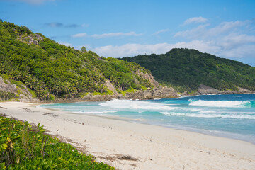 Beautiful isolated white sandy of police bay, turquoise water, lush vegetation, Mahe, Seychelles