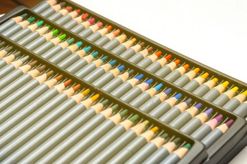 Naklejka premium vibrant array of colored pencils rests diagonally, showcasing a spectrum of hues. The arrangement suggests creativity and artistic potential, inviting exploration and imagination