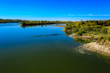 A body of water with a greenish tint and a blue sky in the background
