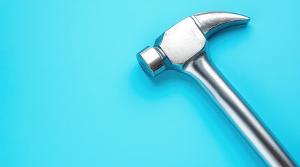 Metal claw hammer resting on a vibrant blue background showcasing tools for construction and repair projects with ample copy space