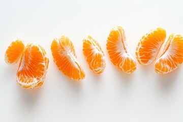 A minimalist composition featuring several peeled segments of a tangerine against a white background