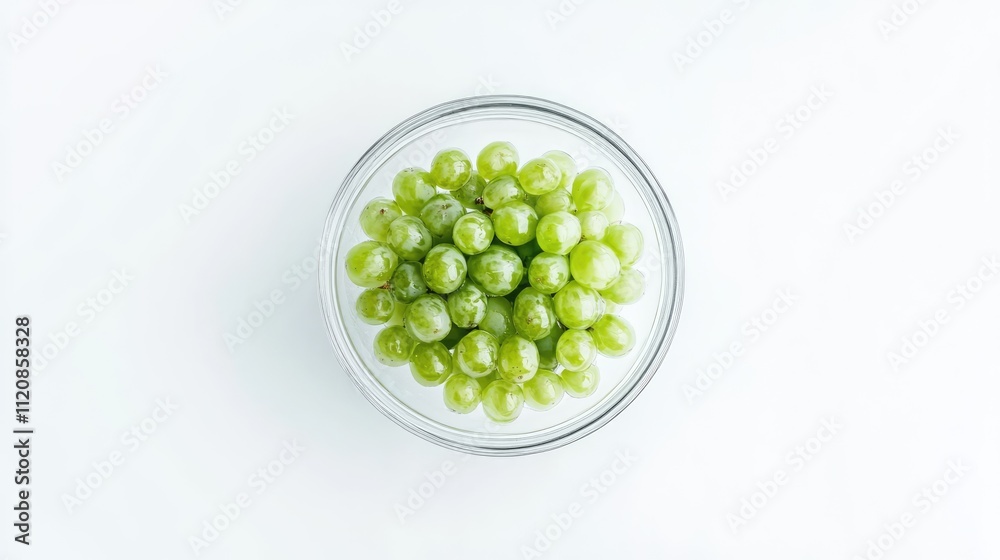 Aufkleber fresh green grapes in a transparent glass bowl viewed from above on a clean white background for hea