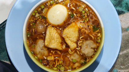 Close up view of indonesia traditional meatball cuisine. Bakso or meat ball, is a food meat balls with noodle, boild egg , tofu served with spicy savoury broth. Top up view.