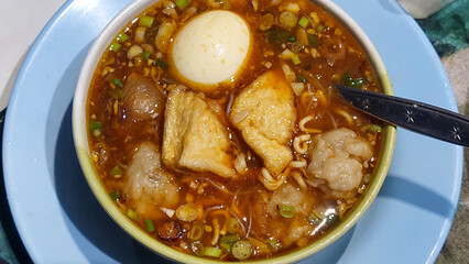 Close up view of indonesia traditional meatball cuisine. Bakso or meat ball, is a food meat balls with noodle, boild egg , tofu served with spicy savoury broth. Top up view.