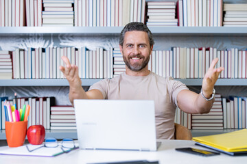 Teachers day. Happy teacher with laptop in school classroom. Knowledge and education with middle aged teacher. Hispanic teacher with book. Teacher from university exam. College teachers.