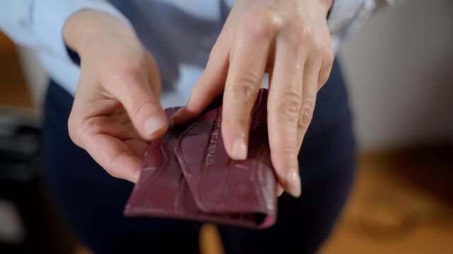 Woman opens red wallet and it is empty