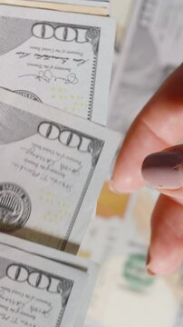 Counting a stack of money to give to a woman, with a ten-dollar bill being handed over in motion.