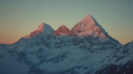 Fototapeta premium A serene mountain landscape at sunset, showcasing snow-capped peaks and a colorful sky.