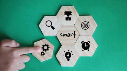 Business and SMART symbol. Wooden blocks with words 'SMART, specific measurable achievable realistic timely'. Yellow background, copy space. Business and SMART concept.