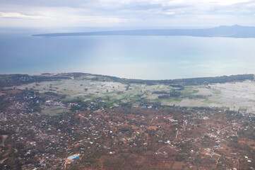 Aerial view of Kupang city, the capital of East Nusa Tenggara Province, Indonesia. Urban landscape with coastline, settlements, built-up areas and some agricultural areas.