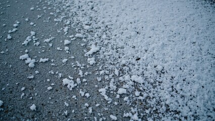 Obraz premium Close-up Detailed Texture of Snowy Asphalt Surface with Small Particles, Winter Scene Background