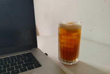 glass of cola with ice at the desk