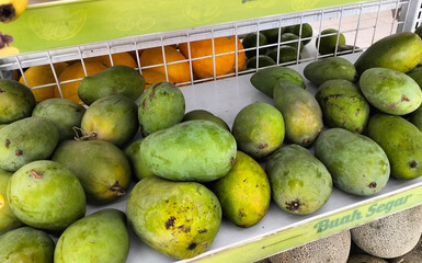 a pile of green mangoes  on the market