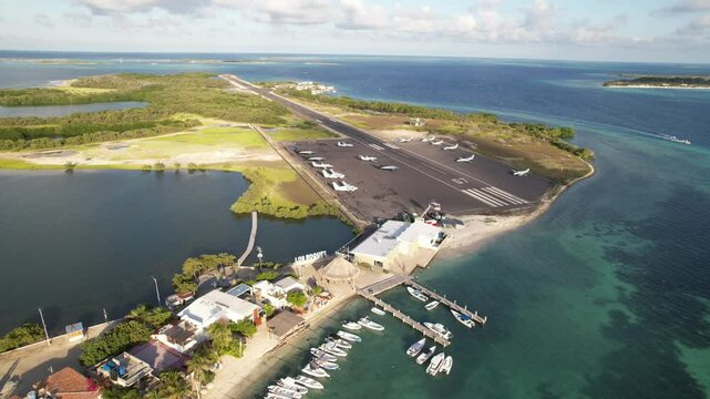 Los roques airport with boats, runway, and blue ocean in a tropical island setting, aerial view