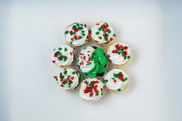 Christmas cupcakes with green stars and pine trees, with white frosting