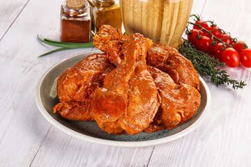 Raw turkey shoulder wing in Indian tandoori marinade
