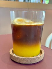 A glass of orange americano in a cafe