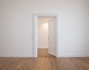 White half-open door and white wall with copy space leading to luminous unknown place