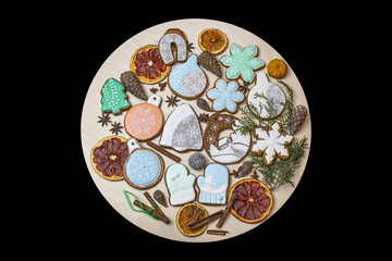 Colorful gingerbread cookies with intricate icing designs arranged on a black background