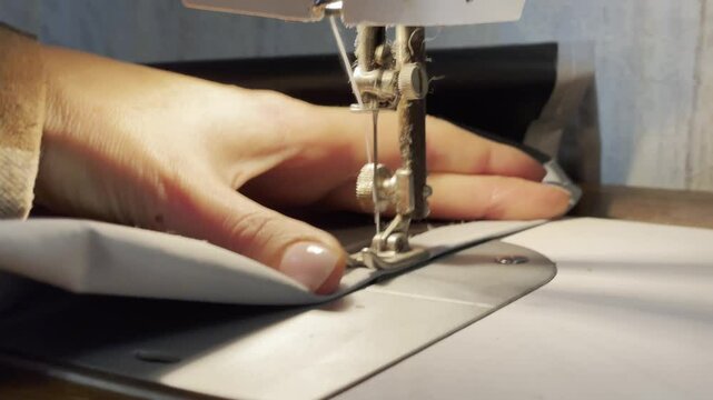 close up of a sewing machine needle in the activity of someone sewing clothes