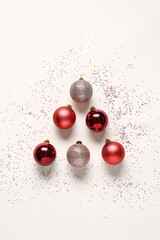 Composition with Christmas balls and confetti on light background
