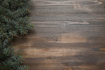 Fototapeta premium Beautiful fir branches on brown wooden background
