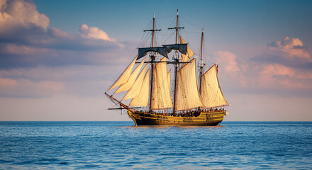 Vintage sailing ship cruising on the ocean at sunset