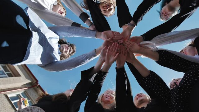 Students happily united in a circle, celebrating their school day success and demonstrating the power of teamwork