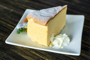 Japanese cheesecake with Clitoria ternatea flower in the plate. Food background.
