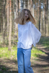 Fototapeta premium Young beautiful girl in a white shirt in the forest.