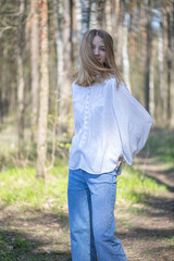 Obraz premium Young beautiful girl in a white shirt in the forest.