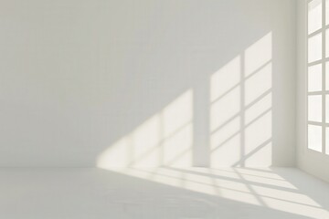 Obraz premium Sunlight streaming through a window in an empty room casts long shadows on the white wall