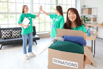 Young female volunteer with donations for poor people in center