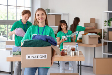 Young female volunteer with donations for poor people in center