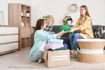 Young women donating their clothes at home