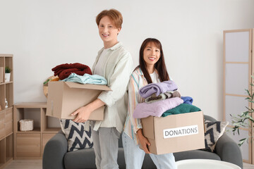 Young couple with clothes for poor people at home