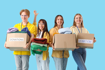 Group of volunteers with donations on blue background
